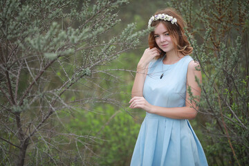 Girl in blue dress in green park
