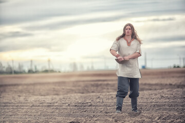 A young peasant sows the field with grain