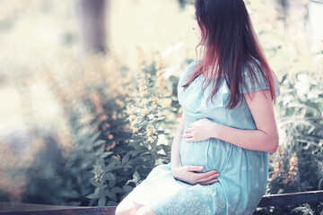 Pregnant girl in a dress in nature