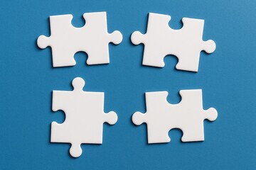 Disassembled white puzzle pieces on a blue surface