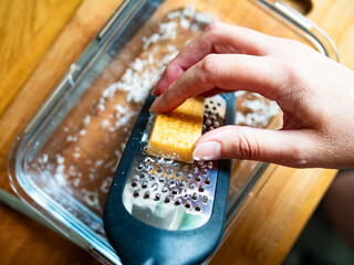 Woman grating parmesan cheese, close-up