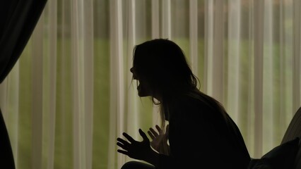 Silhouette of a Woman Expressing Anger Behind Curtains