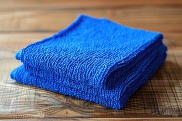 Bright blue textured towel folded neatly on a wooden surface