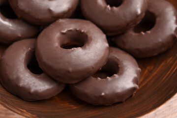 Chocolate donuts in wooden bowl. Sweet baked dessert doughnuts. Close up. 