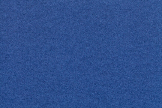 Texture of navy blue paper background with macro structure. Vintage dark denim cardboard backdrop closeup
