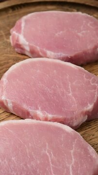 Fresh raw pork escalopes arrangement on wooden surface highlighting texture and cuts