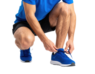 Athletic man in blue shirt tying running shoe laces before workout, preparing for fitness exercise routine