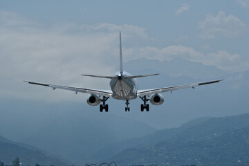 Airplane against the background of mountains and clouds. The plane is ready to land on the runway...