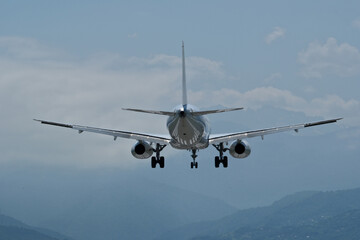 Airplane against the background of mountains and clouds. The plane is ready to land on the runway...