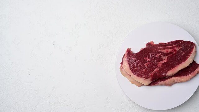 Raw picanha beef steak varieties displayed as marbled cuts on white plate in succession