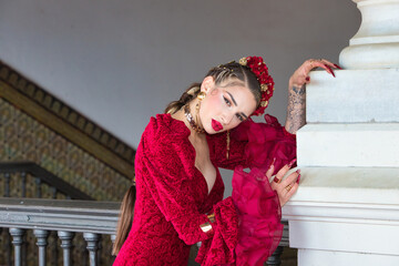 A beautiful woman dancing flamenco leaning against a white column in a square in Seville, Spain....