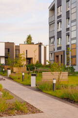 modern residential complex showcases contemporary architecture with landscaped gardens and benches....