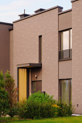 modern townhouse facade with sleek design featuring brick walls and minimalistic windows in urban...