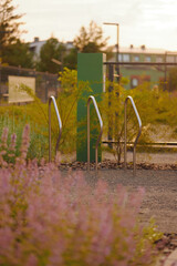 urban park bike stands at sunset create serene, inviting mood. stainless steel structures among...