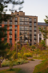modern urban apartment building with lush green surroundings under soft evening light, peaceful...