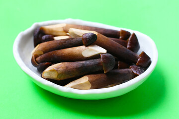 Termite mushrooms with long stems, white tips, and dark brown caps.