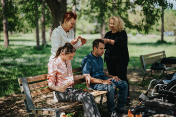 A diverse group of individuals sitting on benches surrounded by greenery, engaging in conversation...