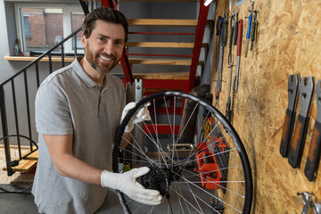 Mechanic man servicing bike using specialized tools in busy workshop