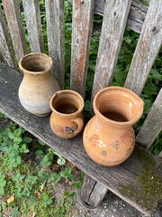 Three ceramic jugs by the fence