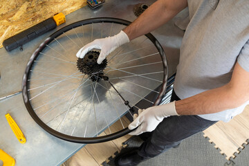 Mechanic man servicing bike using specialized tools in busy workshop