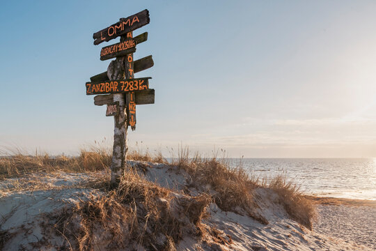 A signpost in Lomma Beach pointing at other surf destinations.