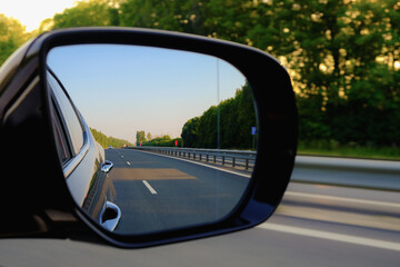 Look in the rear view mirror of a car. Car driving on the road