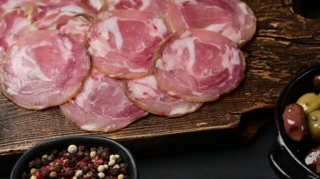 Succulent coppa capocollo arrangement on rustic wooden board with fresh ingredients around