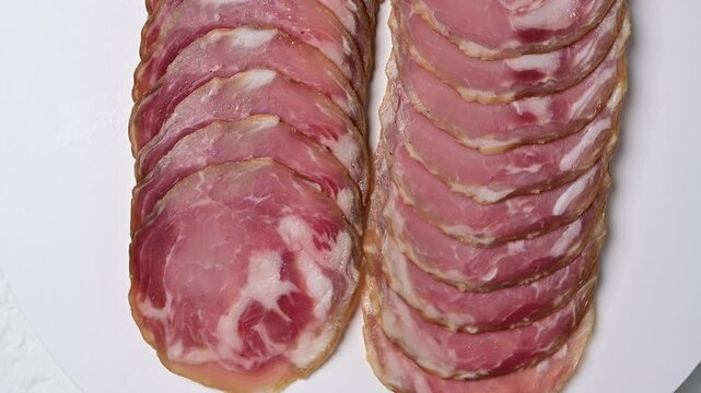 Sliced coppa capocollo preparation and presentation in charcuterie platter