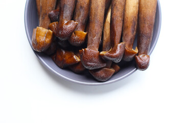 Termite mushrooms with long stems, white tips, and dark brown caps.