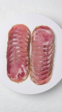 Gourmet artistry: sliced capocollo presentation on white plate