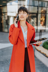 Modern businesswoman in an urban setting, confidently multitasking with a tablet and mobile phone,...