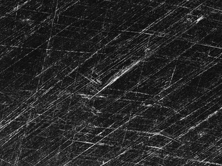 Detailed texture of distressed black surface with scratches illuminated by light from above