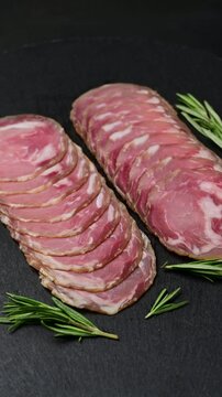 Italian charcuterie: sliced coppa capocollo cured pork arrangement with rosemary