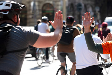 Raised hands of bicyclist and cheering person
