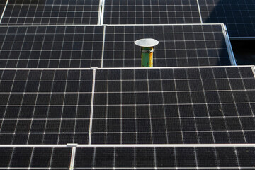 Solar panels installed on the rooftop of a residential building, with a skyline of modern...