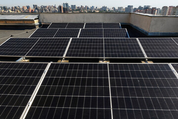 Solar panels installed on the rooftop of a residential building, with a skyline of modern...