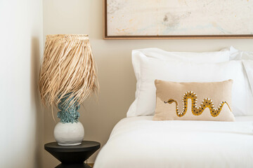 Boho chic bedroom with palm leaf lamp and snake pillow — stylish natural textures, white bedding, handcrafted decor and serene modern interior design for premium home appeal