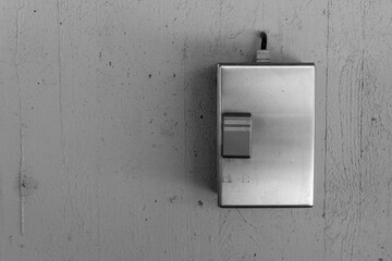 Metal switch plate on a textured wall illuminated by soft light brings a modern touch to...