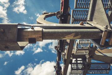 Elevating machinery against a backdrop of vibrant blue skies and fluffy clouds showcasing...
