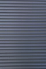 Fototapeta premium Corrugated blue metal wall texture, close-up view of industrial ribbed surface in natural light