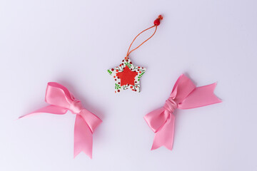Festive Christmas decoration featuring a red ribbon arranged on a white background. Flat lay, top view style. Ideal for holiday cards, invitations, and seasonal designs.