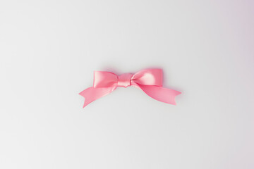 Elegant pink bow on white background. Minimalist composition ideal for gift wrapping, celebrations, greeting cards, and festive designs.