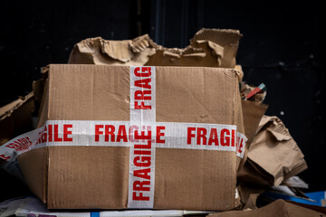 Cardboard boxes awaiting recycling collection on a street, with a shallow depth of field