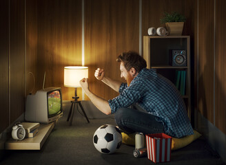 Man watching the football match on TV in a small room