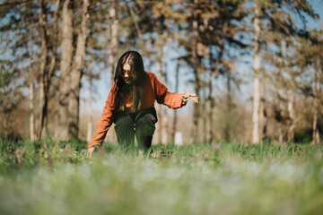 A person outdoors in a park surrounded by trees and grass, showcasing serenity and connection with...