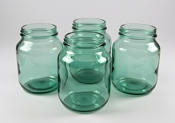 A Collection of Four Green Glass Jars With Wide Mouths and Metal Lids Ideal for Preserving Food and Storing Kitchen Staples Safely and Conveniently