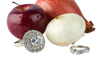 Still life arrangement of a red apple onion and two diamond rings isolated on transparent background