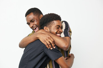 Two joyful African American men share a warm embrace, showcasing friendship and happiness against a...