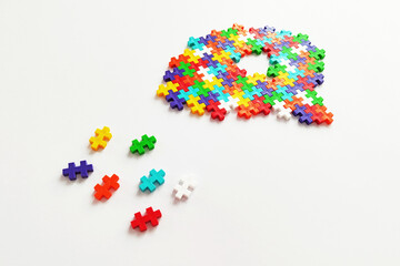 Brain shaped colorful jigsaw puzzle on white background. A missing pieces of the brain puzzle....