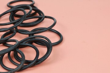 Rubber gaskets. Plumbing pad. Pile of O-ring sealing rubber for repairing hydraulic system with different sizes isolated on brown background.